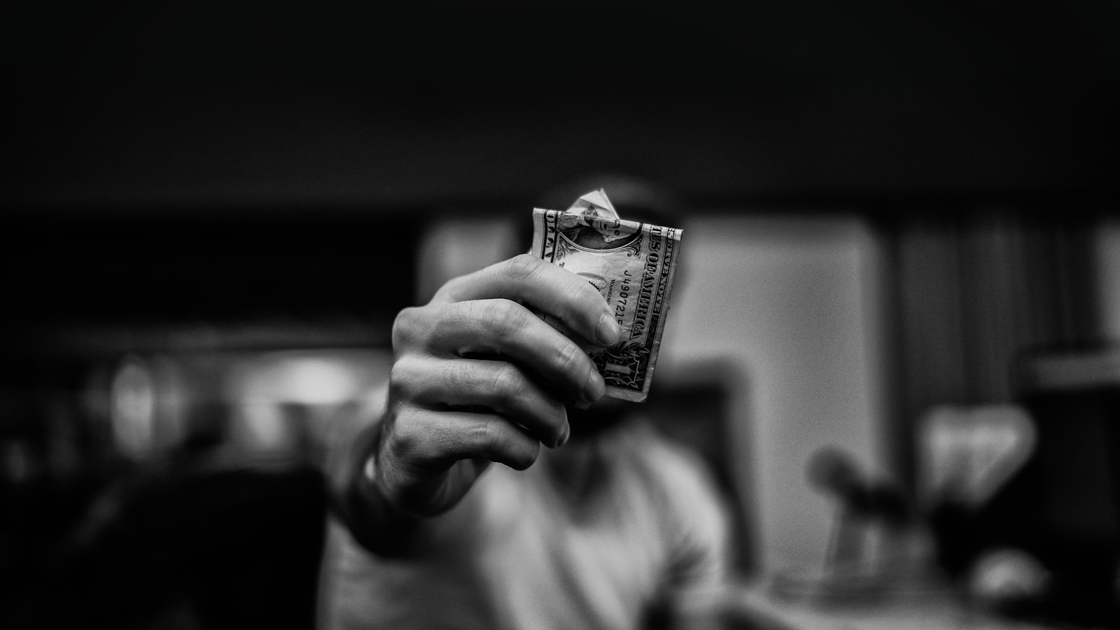 man holding 1 US dollar banknote findom